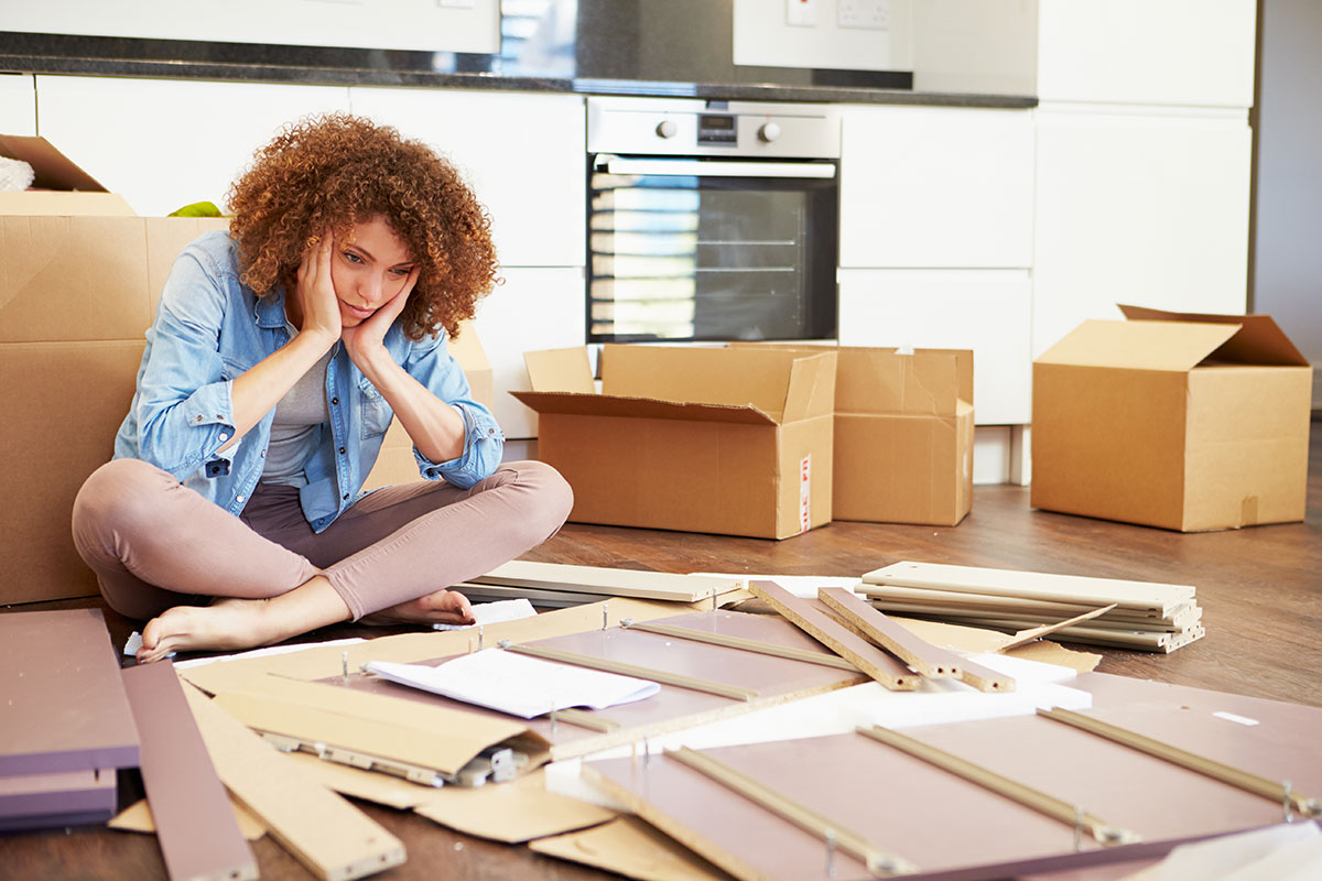 Personne fatiguée devant ses meubles à monter après un déménagement