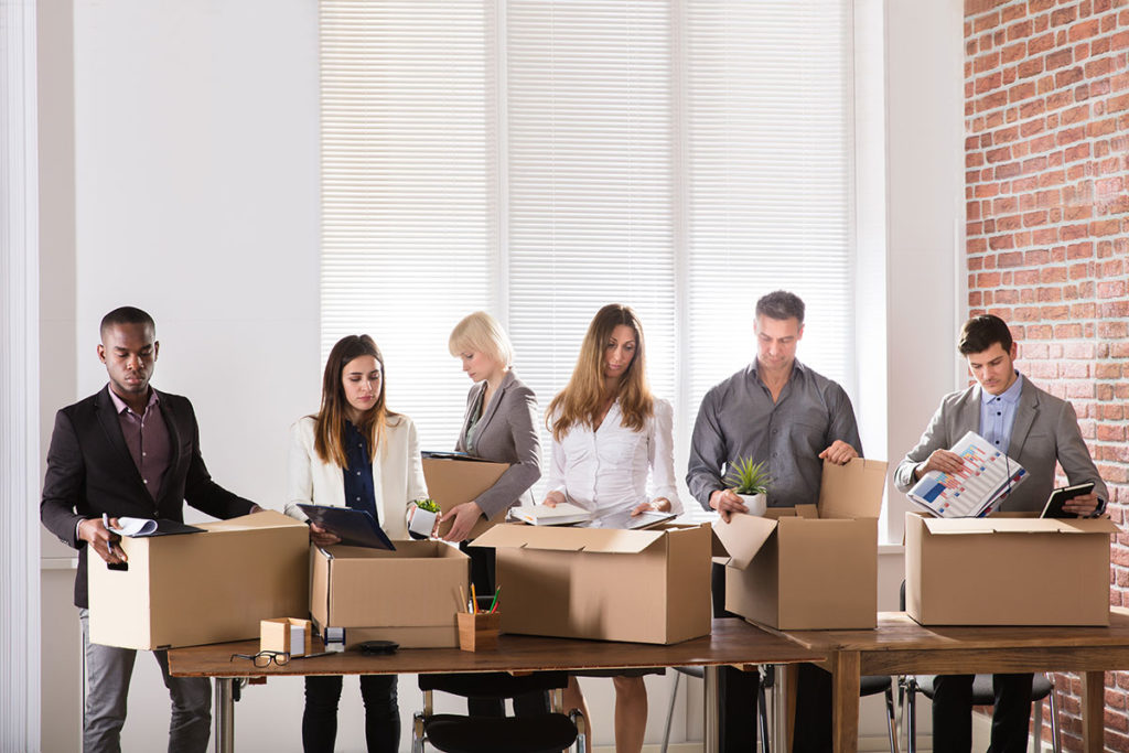 Plusieurs personnes tenant un carton de déménagement