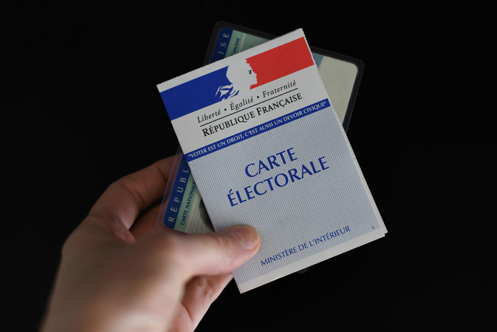 Personne tenant sa carte électorale et sa carte d'identité